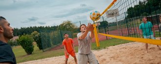 Fünf Männer spielen Volleyball.